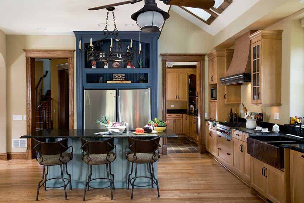 The blue painted maple armoire cabinet that houses the refrigerator adds a bold pop of color to the kitchen.