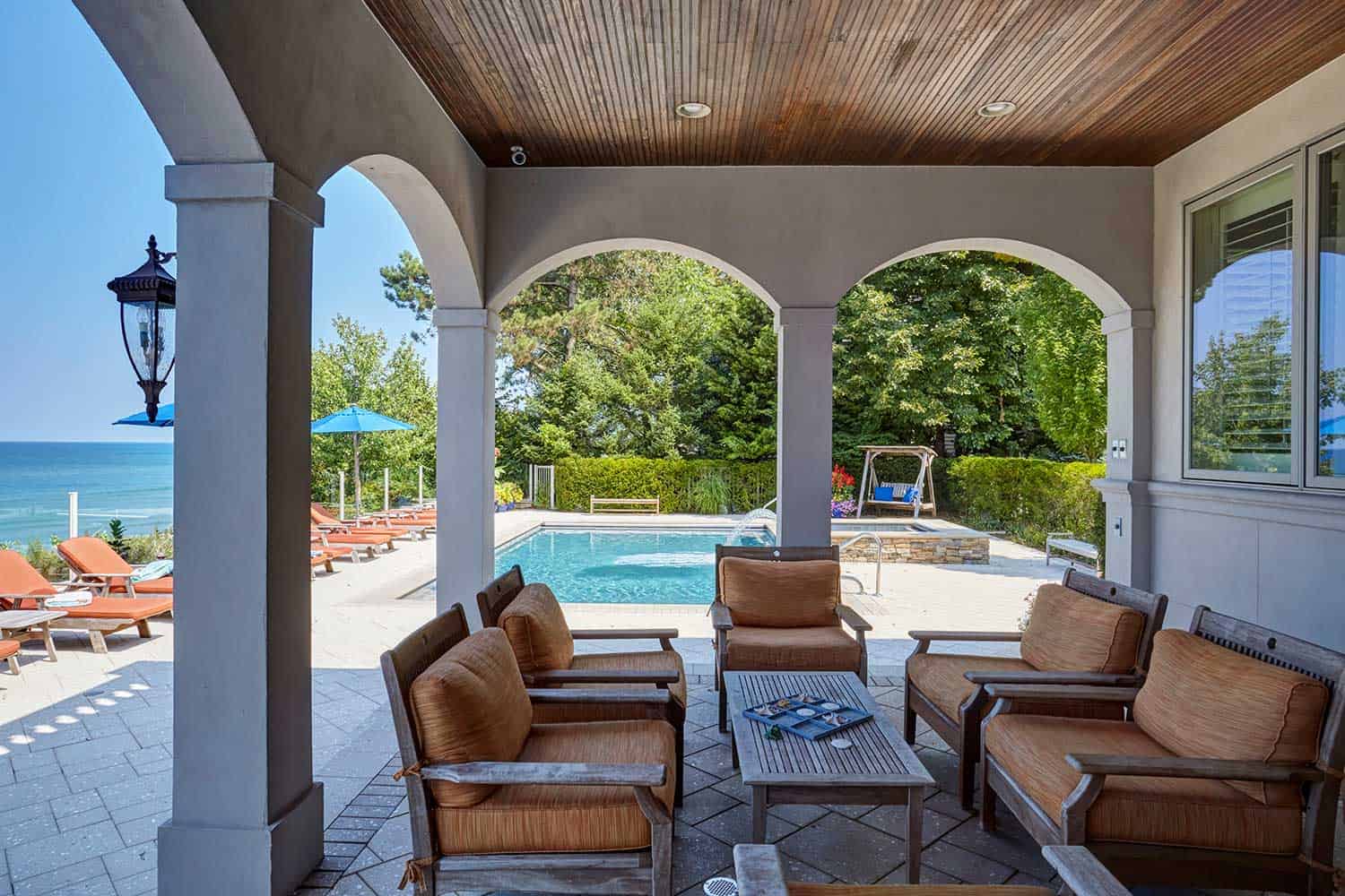 covered-patio-arched-openings-by-pool-harbor-country