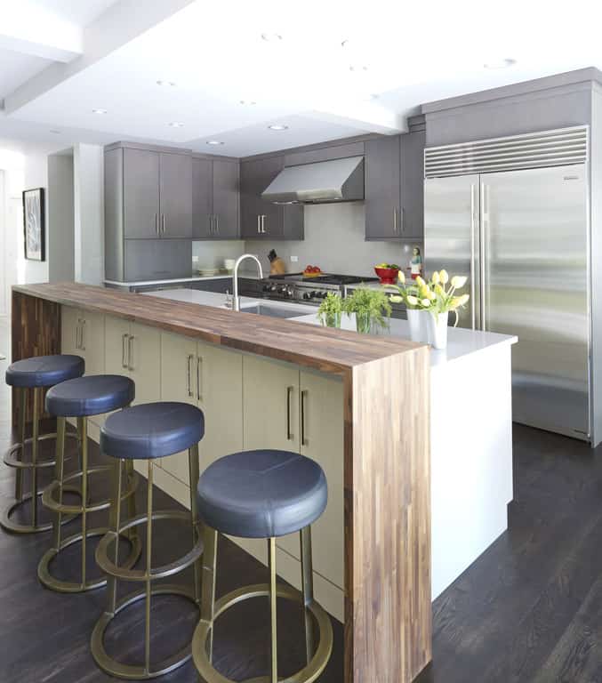 Blue leather bar stools in open concept kitchen Bright open concept kitchen with an island bar and bar stools made of blue leather and gold metal bases.