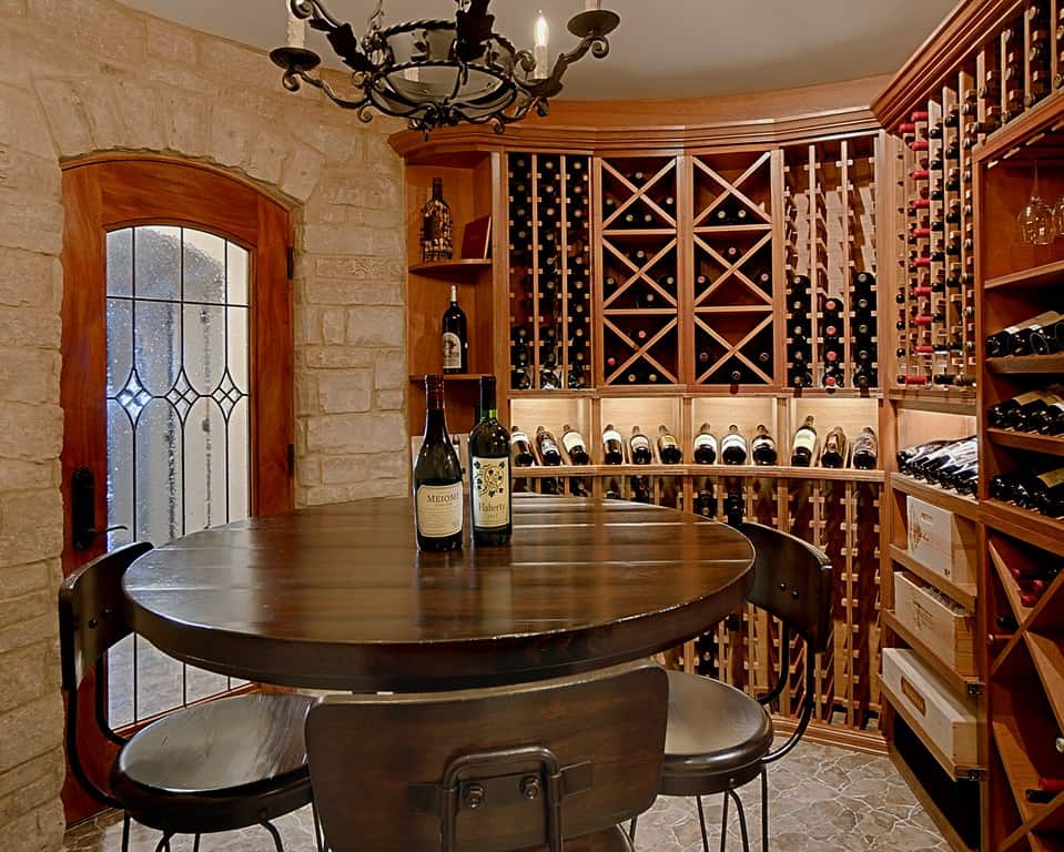 A rounded hardwood table surrounded by a custom wine cellar with circular walls and overhead lightingwine cellar.