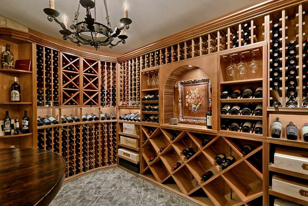 A custom wooden wine cellar with wooden wine racks and overhead lighting