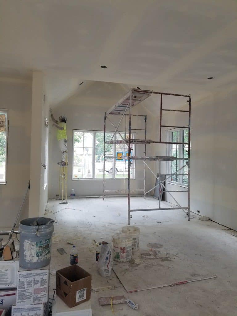 worker applying mud to drywall