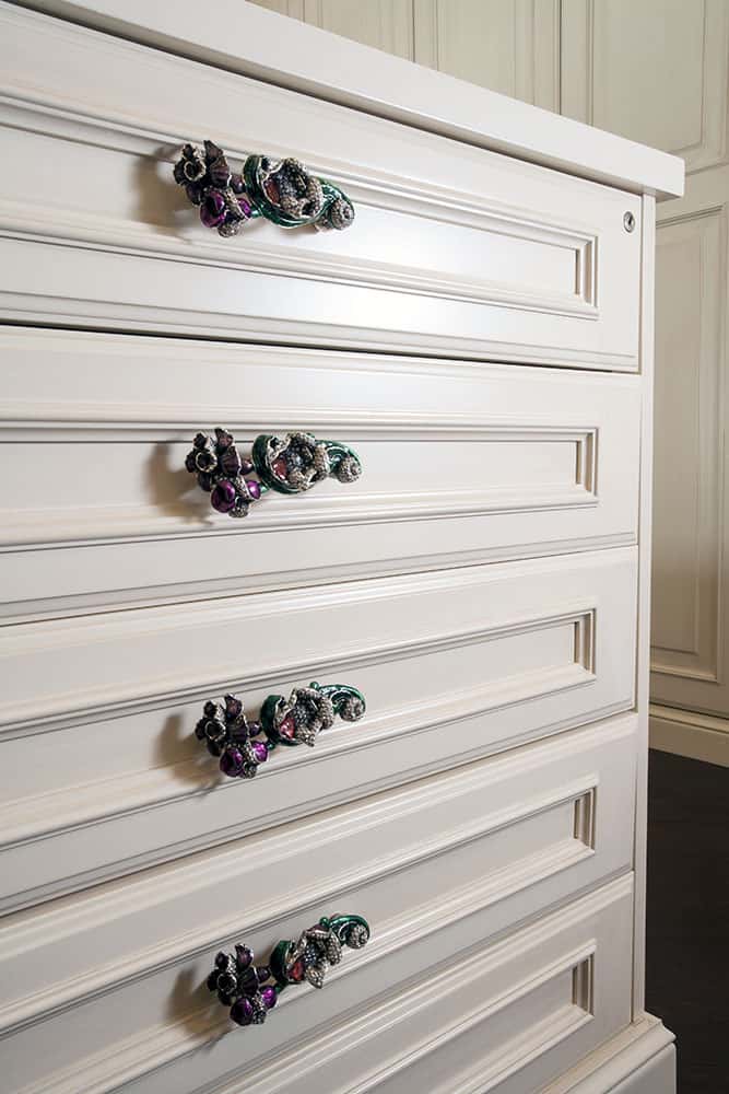 white raised panel dresser with custom drawer pulls that look like gemstones