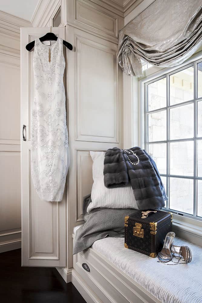 window seat in master closet with fur coat and louis vuitton makeup trunk