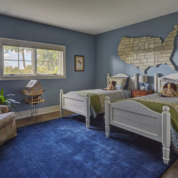 blue-childs-bedroom-with-kitsch-artwork child's bedroom with dual twin beds and large blue area rug