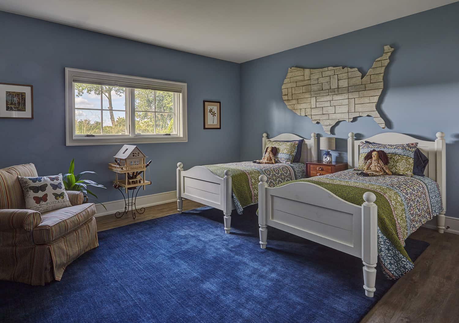 child's bedroom with dual twin beds and large blue area rug