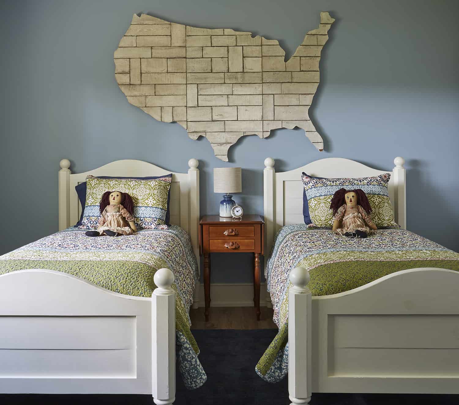 twin beds with dolls on bed and large wooden us map