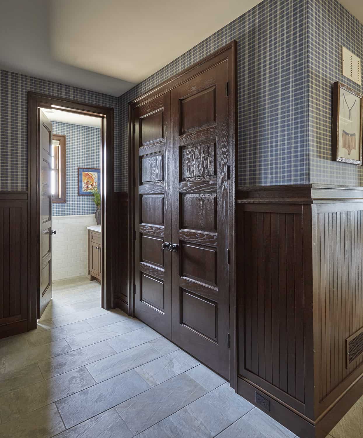 mudroom closet with dark wood recessed panel french doors