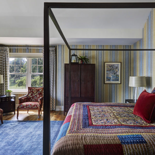 master-bedroom-with-colorful-bedding-and-striped-walls poster bed with colorful bedding