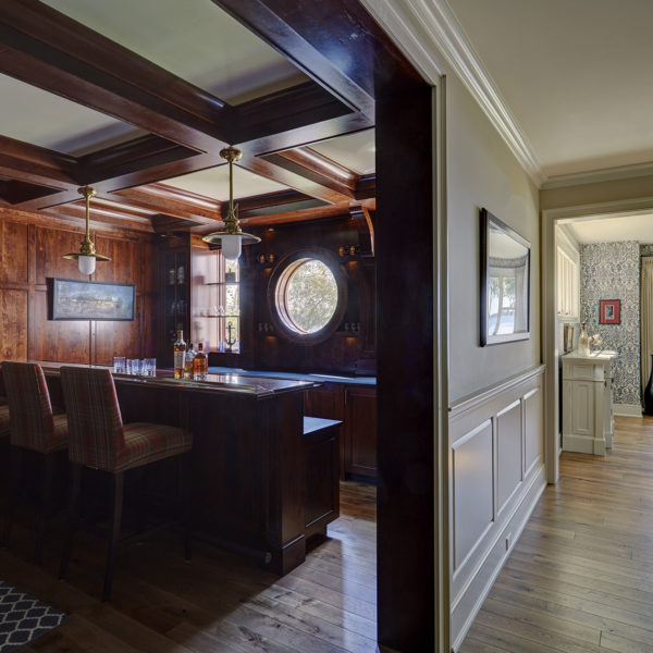 view-of-dining-room-and-home-bar-from-hall home bar with dark wood paneling