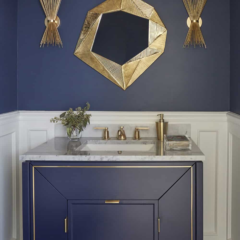 stylish blue vanity with blue wall and gold accents