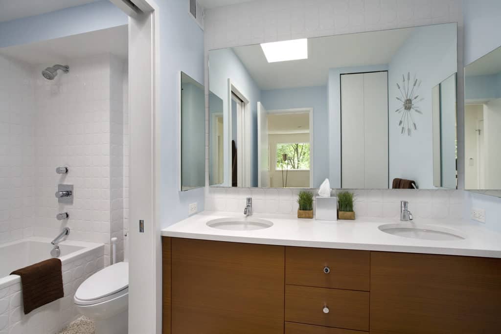 compact bathroom with his and her sink