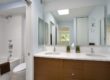 compact bathroom with his and her sink