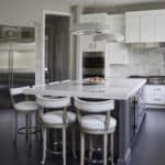 contemporary kitchen with dark island and white perimeter cabinets