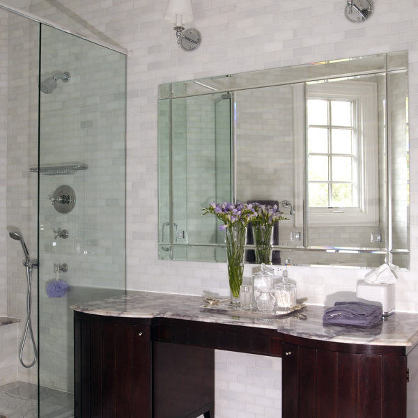 dark wood vanity and fully tiled marble walls