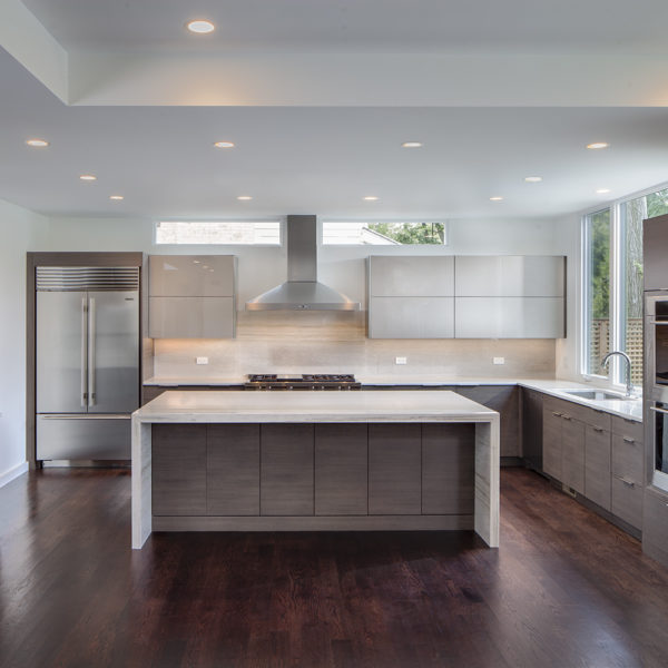 modern kitchen with gray cabinets and waterfall edge countertop
