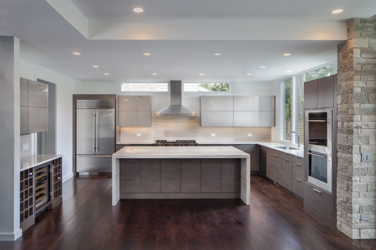 modern kitchen with gray cabinets and waterfall edge countertop