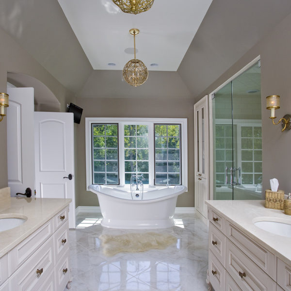 vaulted ceiling with large soaking tub and his and her sinks