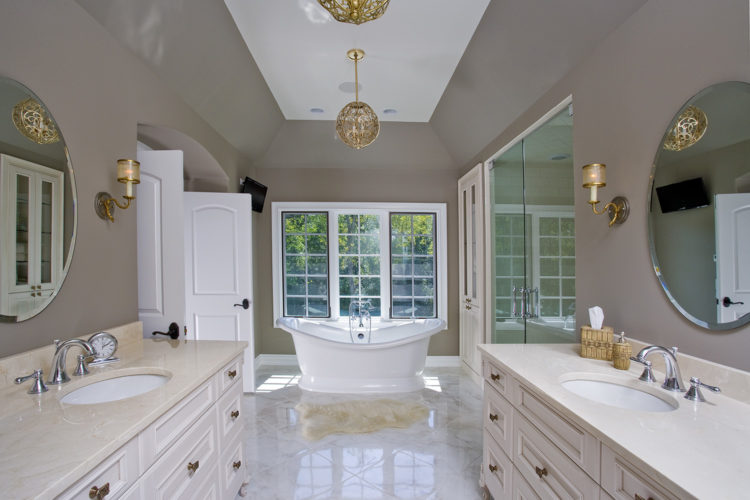vaulted ceiling with large soaking tub and his and her sinks