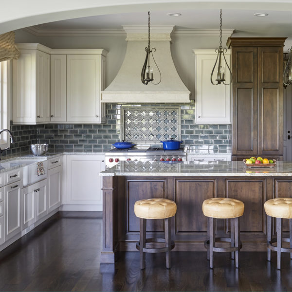two tone cabinetry and art tile backsplash