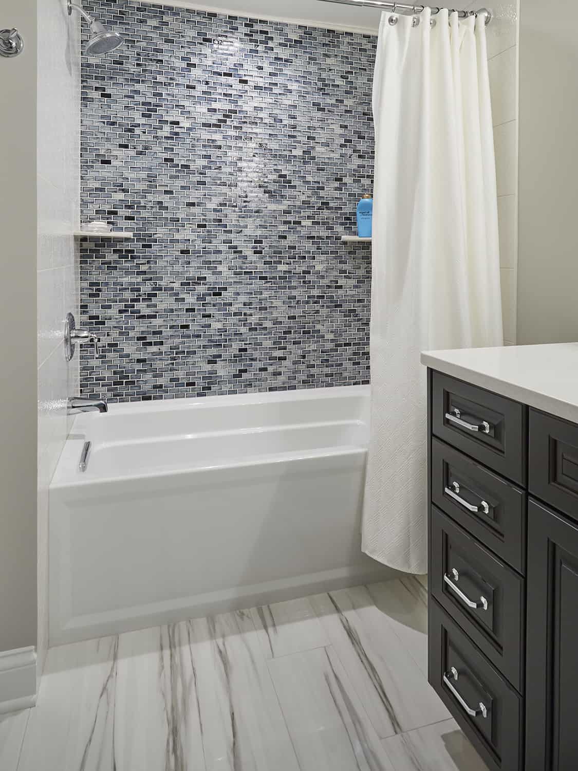 new lower level tub shower combo with blue tile accent wall