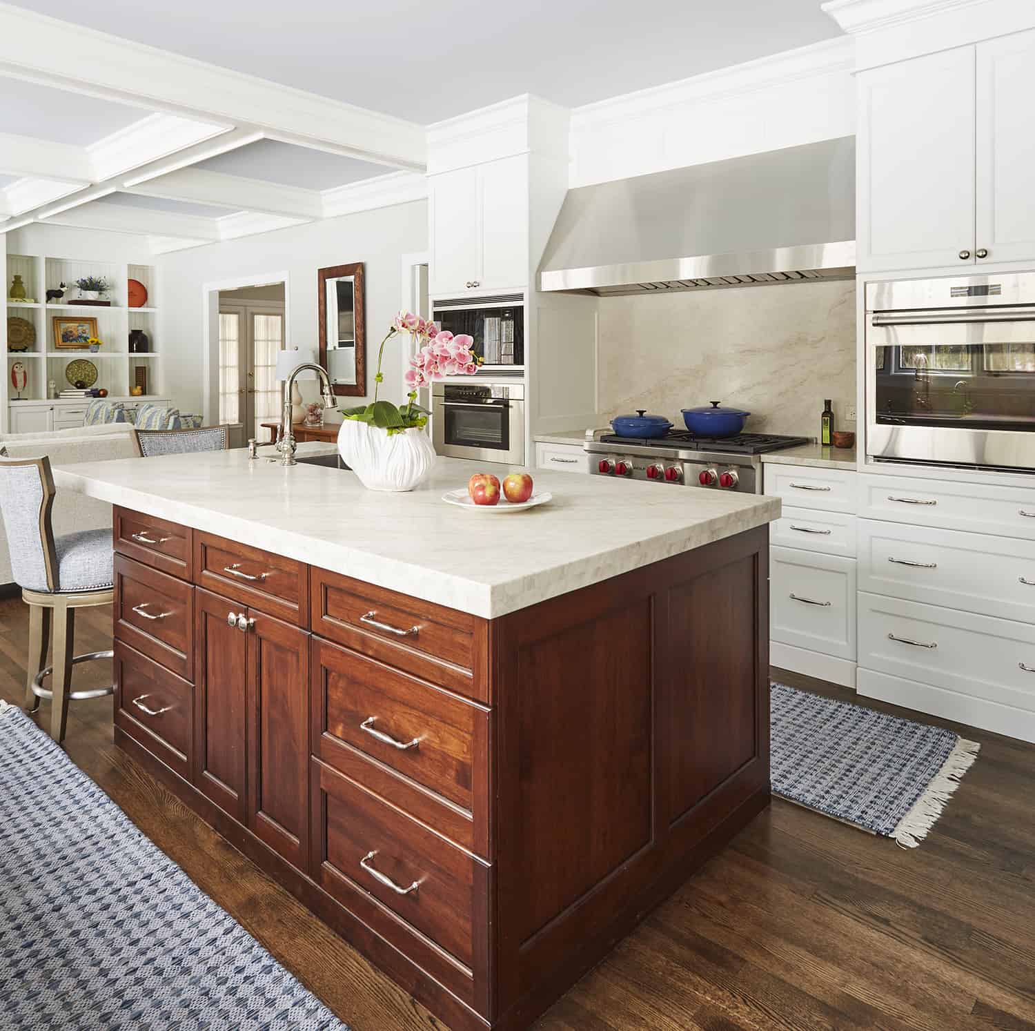 dark wood island with white cabinets on outside walls