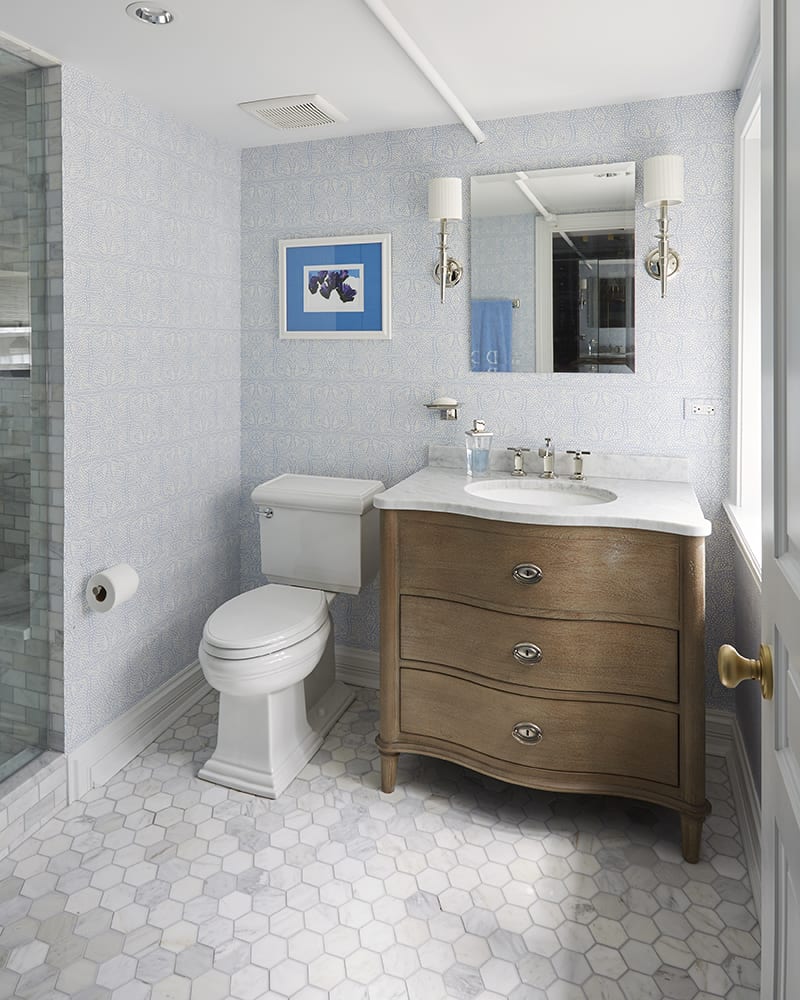 medium wood vanity with stone flooring