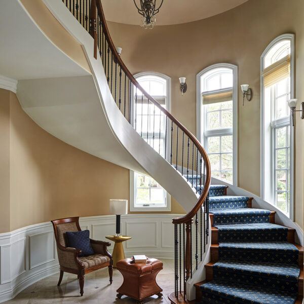 curved staircase with blue carpet runner