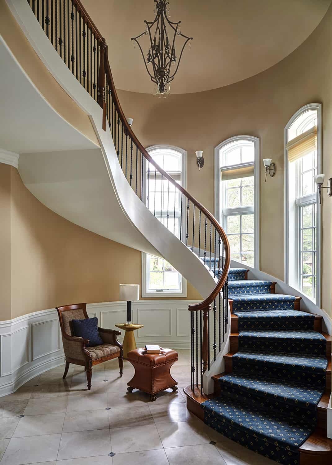 curved staircase with blue carpet runner