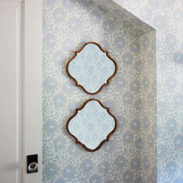 two mirrors on patterned wallpaper wall