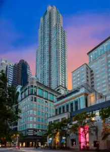 Picture of a bustling city skyline with tall skyscrapers illuminated at dusk