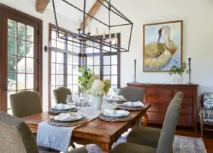 Picture of a dining room with a long wooden table and a large painting of a crane on the wall