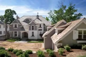 Picture of a grey house undergoing renovations with exposed dirt in the front yard