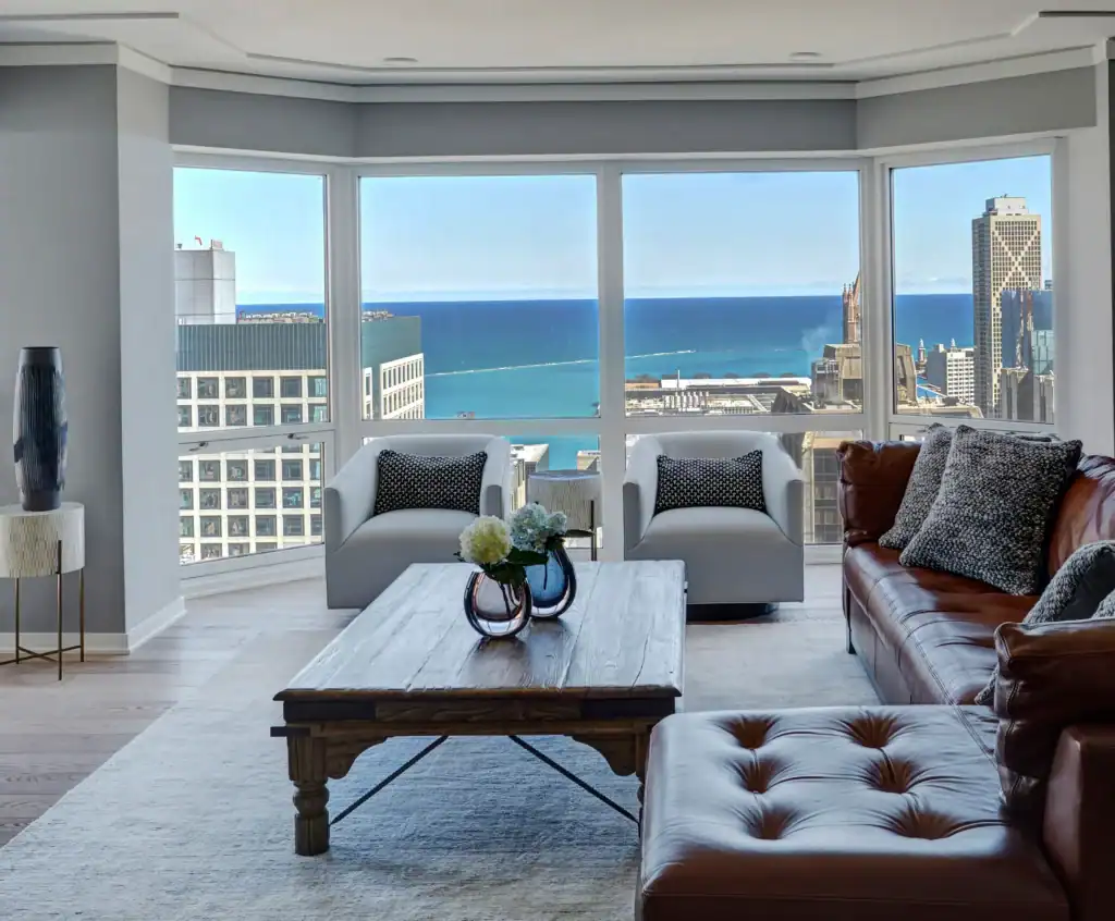Picture of a high rise living room with a leather couch and a view of the lake