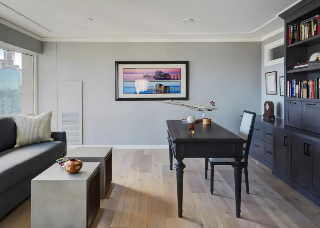 Picture of a modern office space with a dark desk and a model airplane on display