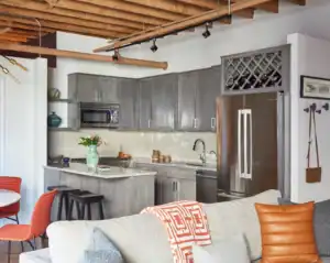 Picture of an open concept living space with grey kitchen cabinets and a cozy seating area