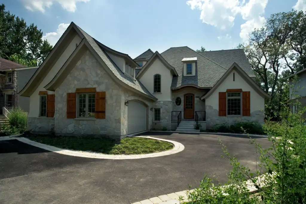 Picture of a beautiful stone and stucco house exterior with a curved driveway