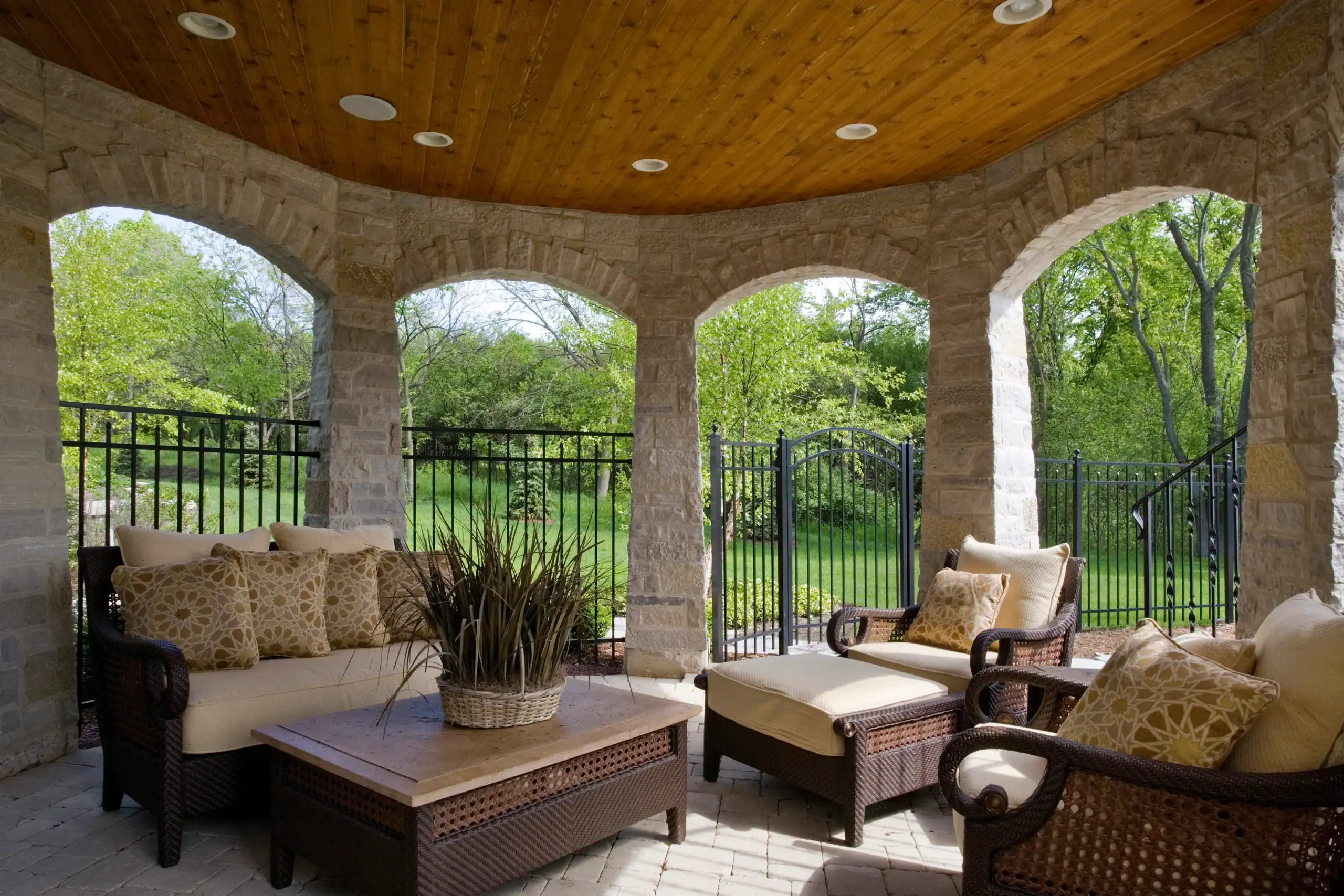 Picture of a covered outdoor stone patio with arched openings and comfortable lounge furniture. Picture of a covered outdoor stone patio with arched openings and comfortable lounge furniture.