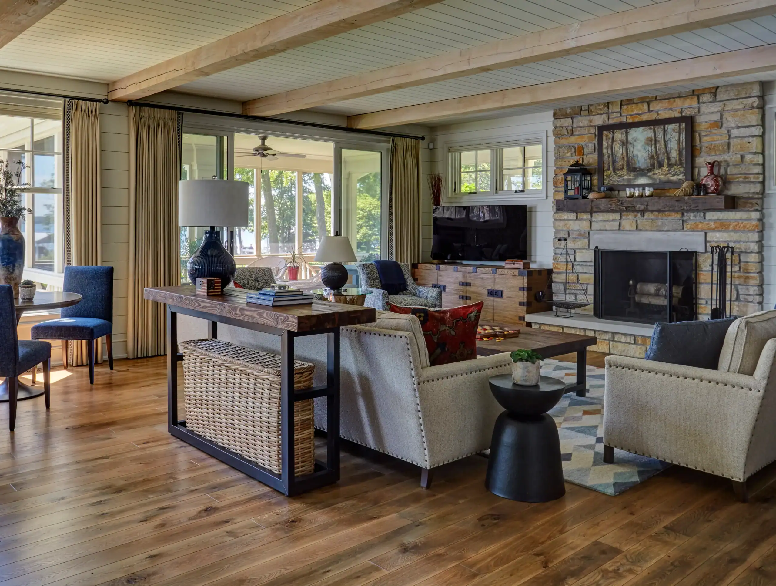 Picture of a rustic living room with exposed wood beams and a large stone fireplace. Picture of a rustic living room with exposed wood beams and a large stone fireplace.