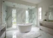 Picture of a white freestanding bathtub in a luxury marble bathroom with a large glass shower
