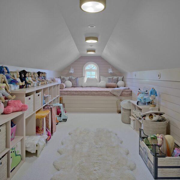 Finished attic playroom featuring a built-in window seat, shiplap walls, and custom toy storage.