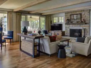 Picture of a living room with a stone fireplace and wooden beams