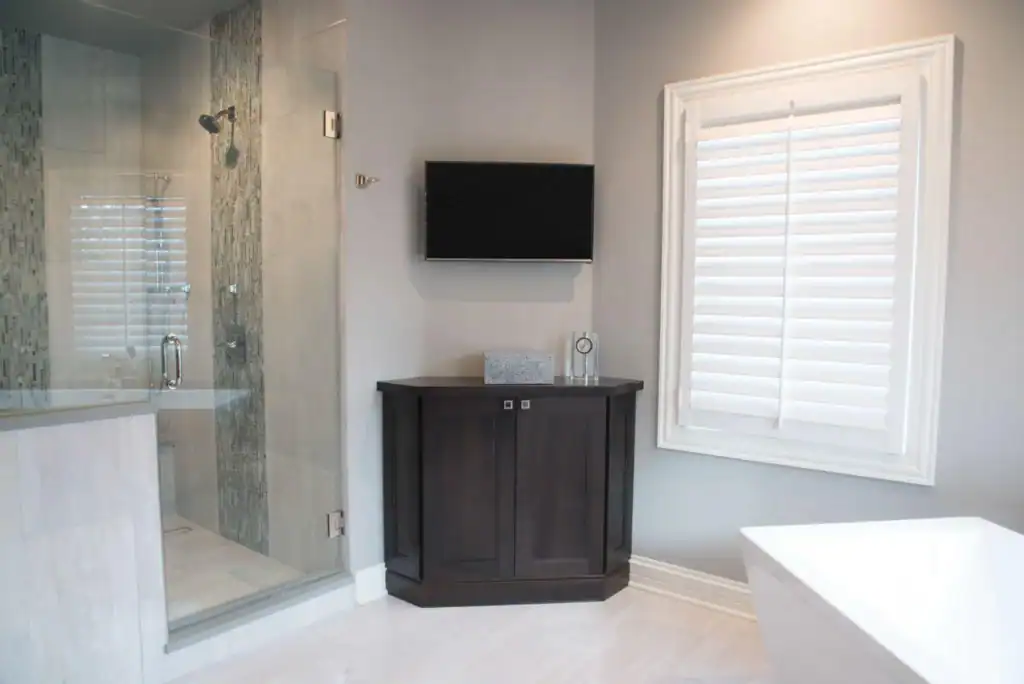 picture of a dark wood corner cabinet beneath a wall mounted tv