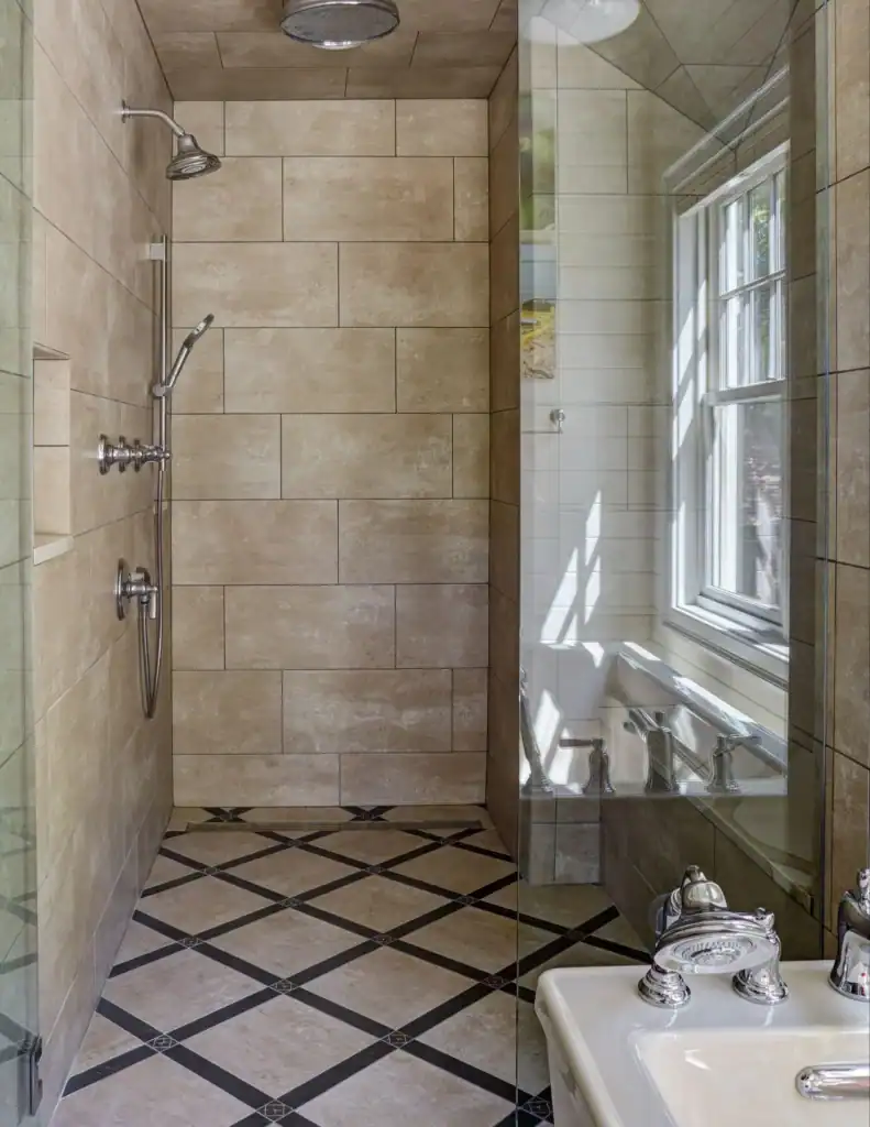 picture of a glass shower with tan tiles and a diamond floor pattern