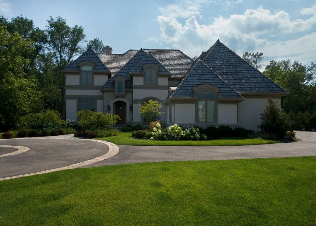 picture of a luxury stone and stucco home with a curved driveway